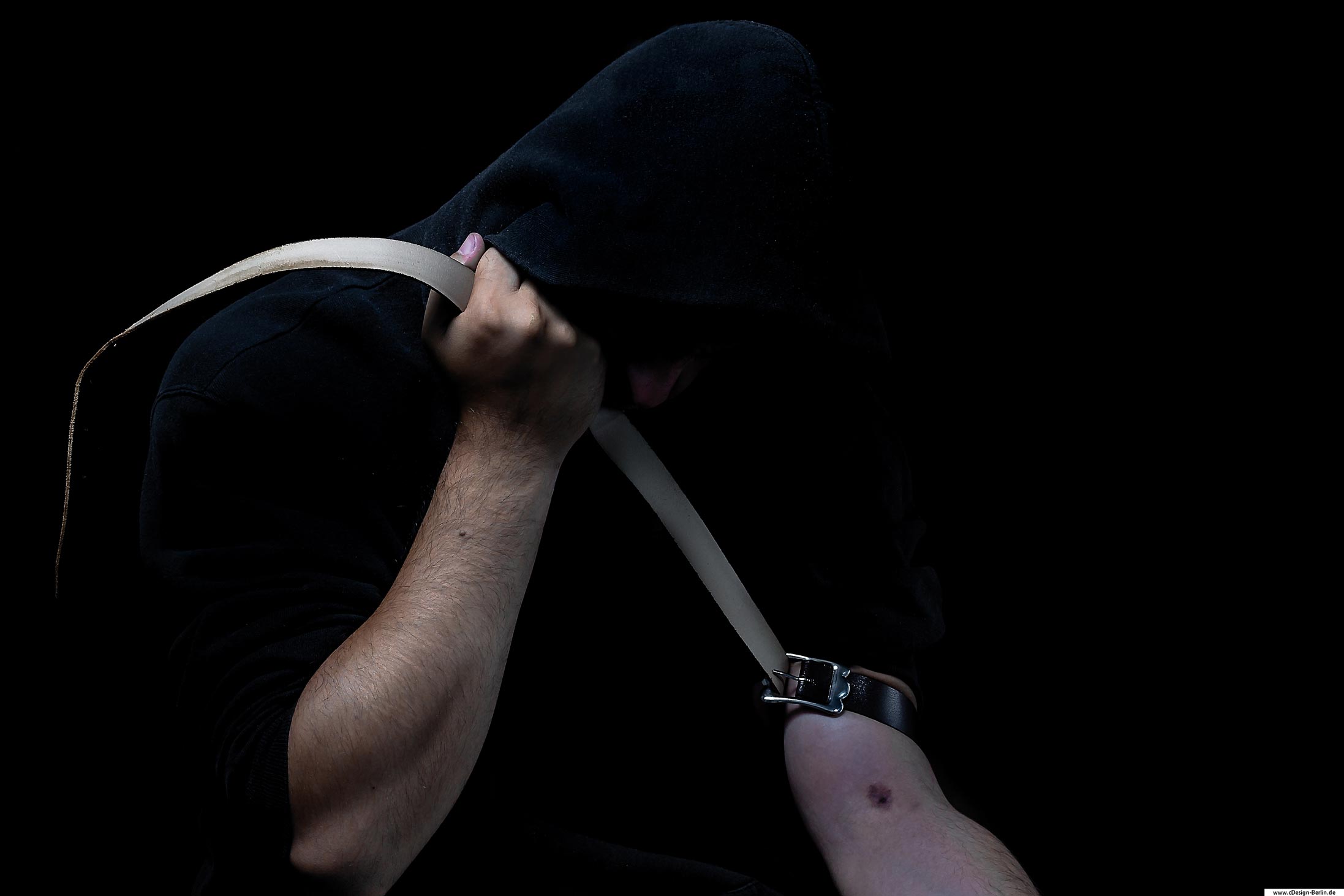 Einmal in die Falle getappt, findest du sehr schwer wieder heraus. Drogen sind nicht die Lösung deiner gebrochenen Seele. Nur du hast die Kraft und Macht dein Leben in die Hände zu nehmen. Bleibe klar, stark und komme erst garnicht in Versuchung, denn erst dann wird dein Problem zu einem viel Größerem. Bewege dich nach vorn, wirf dich nicht zurück, leg die Nadel beiseite und fange an zu LEBEN!!! Dieses Foto ist sehr dunkel, fast schon düster gehalten. Hierauf sieht man einen Mann, sein Gesicht von einer Kapuze bedeckt, sein Blick nach unten gerichtet. Sein rechter Arm augestreckt mit einer sichtbaren Einstichstelle, um den Oberarm einen Gürtel. Der linke Arm zieht den Gürtel fest.